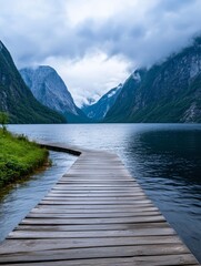 Obraz premium Wooden Path to Misty Mountain Lake - Serene landscape; wooden path extending to a misty lake, surrounded by majestic mountains. Symbolizes tranquility, journey, nature's beauty, exploration, and peace