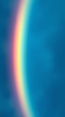 Fototapeta premium Blurred rainbow on blue sky vertical phone wallpaper background.