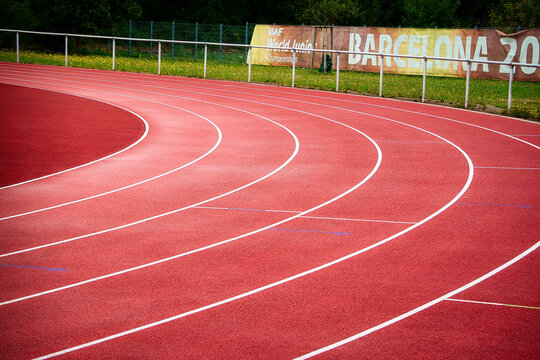 Blick auf den Kurvenbereich einer Tartanbahn mit Werbebanner f&uuml;r die IAAF World Junior Championships in Barcelona im Jahr 2012