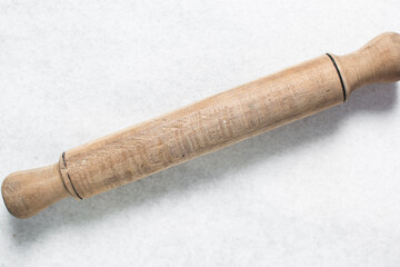 Top view of wood rolling pin on a white granite countertop, overhead view of a wooden rolling pin