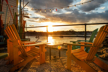 wooden chairs on a fishing pier at sunset. gulf coast. Maine. USA. Fishing village.