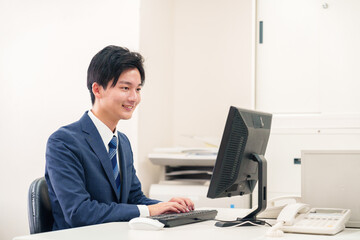 オフィスでデスクワークをする若い男性