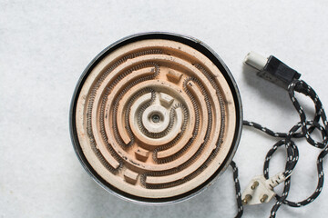 Overhead view of mini electric ceramic stove with copper wire ring on a granite countertop