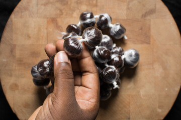 nigerian baba dudu candy in a brown wood counter, top view of Ghana coconut candy or kube toffee candy, hard candy made with coconut milk and sugar on wood countertop