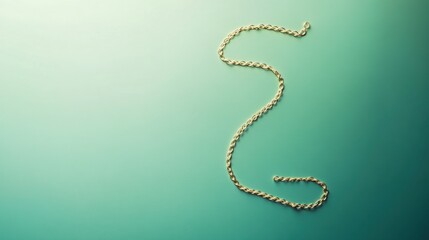 Naklejka premium A simple gold chain necklace coiled neatly on a gradient teal background