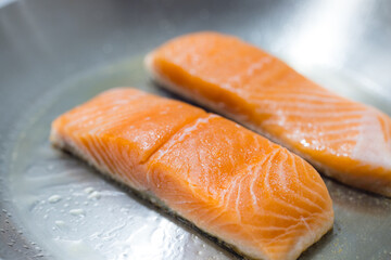 Fresh salmon fillets cooking on hot pan