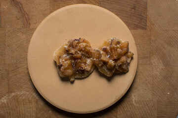 Overhead view of nigerian coconut candy on a wood countertop, top view of candied coconuts discs, flatlay of bukayo candy or coconut drops