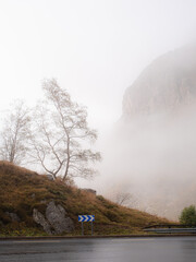 The road from Andorra to France. Driving through the Pyrenees Mountains on the border between France and Andorra on a foggy day. The fog would occasionally break and gives glimpses of the mountains. 