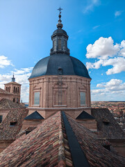 Looking over the rooftop of a religious building. This view is over the UNESCO World Heritage site of Toledo, Spain. The view from the roof shows the medieval city in Spain and a church steeple.