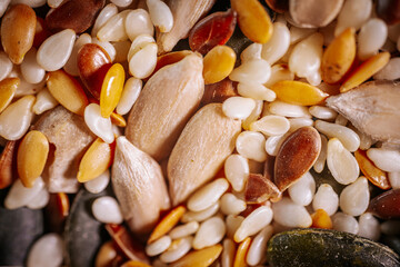 A vibrant close-up of a seed mix featuring pumpkin seeds, flaxseeds, sesame seeds, and sunflower seeds. The colorful textures highlight the variety and freshness of the seeds.
