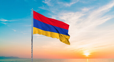 Waving flag of Armenia against the background of a sunset or sunrise. Armenia sky with flying flag beauty.  Concept of national holidays. Armenia flag for Independence and Commemoration Day.