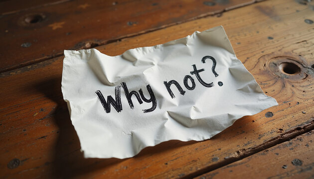 Crumpled paper with "Why not?" on rustic wooden table
