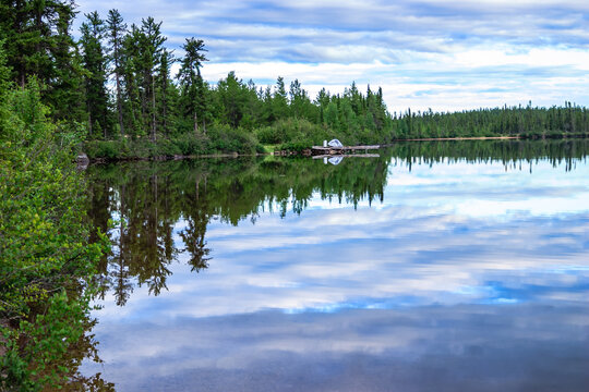 A lake with a small cabin on the shore