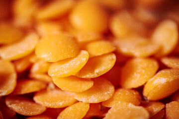 A close-up view of vibrant orange lentils, highlighting their smooth, flat texture and natural color. Ideal for showcasing healthy, plant-based food options.
