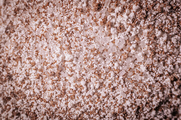 Macro shot of granulated instant coffee mix featuring sugar, milk powder, and coffee crystals. Detailed texture of the ingredients creates a vibrant composition.
