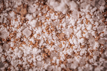 Macro shot of granulated instant coffee mix featuring sugar, milk powder, and coffee crystals. Detailed texture of the ingredients creates a vibrant composition.