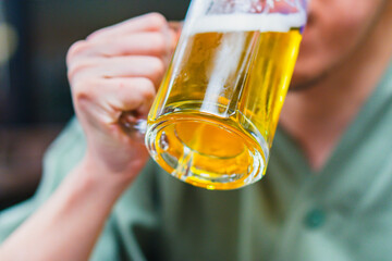 ジョッキでビールを飲む男性の手元