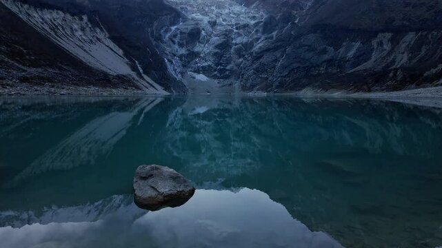 Manaslu, Nepal: Tilt up footage of the dramatic Birendra Lake at the bottom of the Manaslu mountain peak near the Sama village in the Himalayas in Nepal in late afternoon on a cold winter day