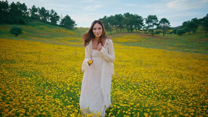 Fototapeta premium Country woman enjoy flowers plantation gloomy summer day. Girl taking bloom