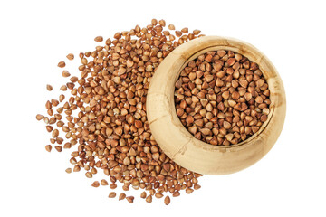 Raw buckwheat in wooden bowl isolated on white background. Top view. Flat lay
