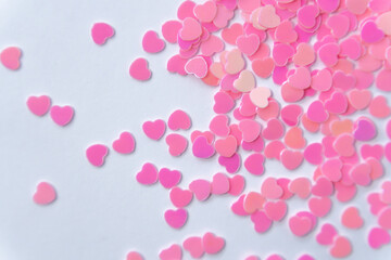 Play of Color and Shape: Pink hearts in various shades form a vibrant pattern on a white background, symbolizing romance and tenderness. 