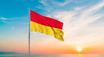 Waving flag of Baden against the background of a sunset or sunrise. Baden sky with flying flag beauty.  Concept of national holidays. Baden  flag for Independence and Commemoration Day.