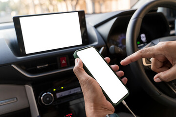 Close-up male hand holding smartphone with blank on screen against background vehicle interior.