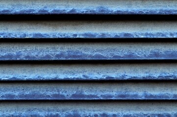 Metal blinds on the window covered with a thick layer of dust
