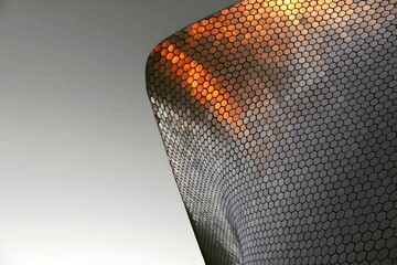 A close-up photograph of a modern building facade featuring a repeating hexagonal pattern, creating a visually striking and textured surface.