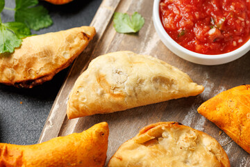 Freshly served traditional empanadas on wooden board. Mexican food