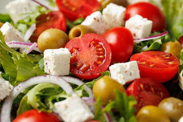Fresh Mediterranean salad with feta cheese, tomato, olives, onion and basil leaves, Healthy home made food