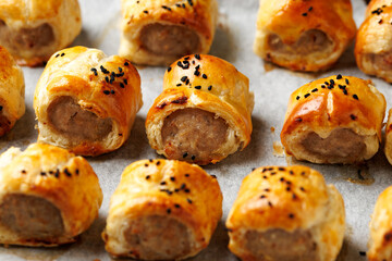 Freshly baked English Sausage rolls with ketchup. Party snack food.