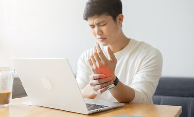 close up employee man massage on his hand and arm for relief pain from hard working on the desktop...