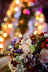 Floral display with soft lights. A vibrant floral arrangement with various blooms and greenery is illuminated by soft, colorful lights in the background.