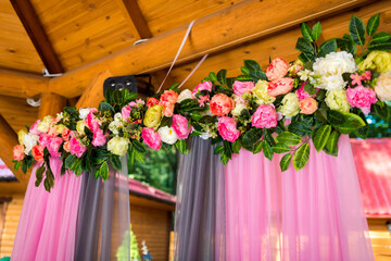 Pink-draped floral decor. A beautiful arrangement of colorful flowers on a backdrop with soft pink...
