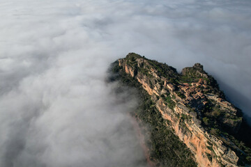 Aerial view of Siurana village in the sea of clouds on sunny winter day. Tarragona Province, Spain.