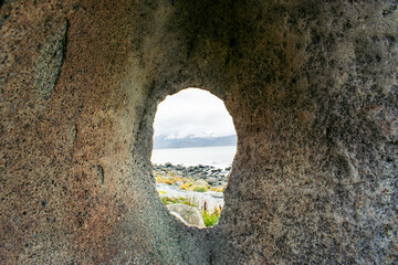 A bizarre boulder with a hole on the sea coast of Norway