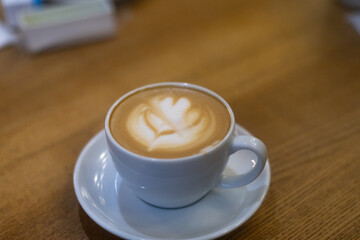 cup of cappuccino with foam on a wood texture table