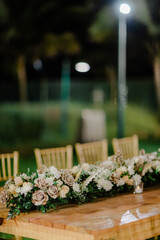 A romantic white beach wedding celebration with an outdoor ceremony, featuring elegant decor, a bottle for colored sand rituals, and a beautifully arranged table under the open sky