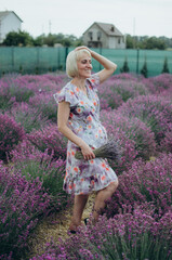 Elegant woman holding lavender bouquet in blooming field