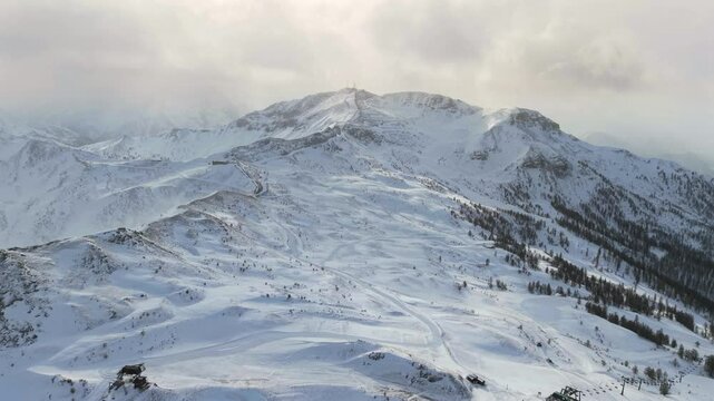 Aerial of snow covered montain peak top ski resort Vialattea Italy