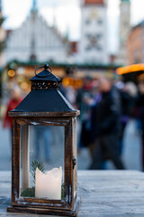 Lantern with a wax candle sits on a wooden table at the Munich Marienplatz Christmas Market