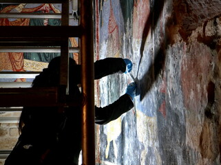 Restorer paintings on frescoes of religious motifs in Orthodox Christian monasteries