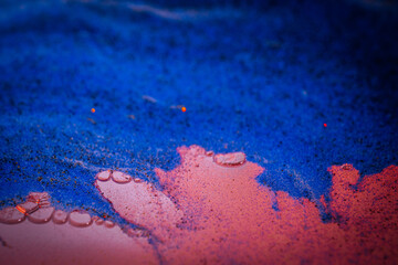 A textured abstract composition with vibrant blue and pink hues that seamlessly blend. Granular...