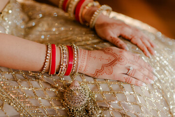An Indian bride's hand adorned with intricate henna designs symbolizes beauty, tradition, and the...