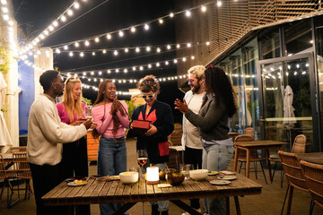 Excited woman receiving birthday gift from friends at outdoor party