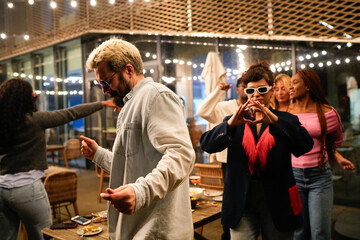 Multiethnic friends dancing together at a night party