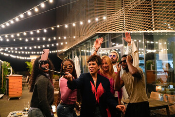 Multiethnic friends taking selfie at rooftop party