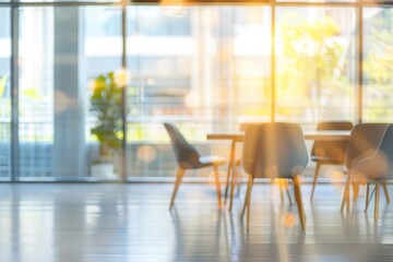 Sunlit modern office space with chairs and table near large window.