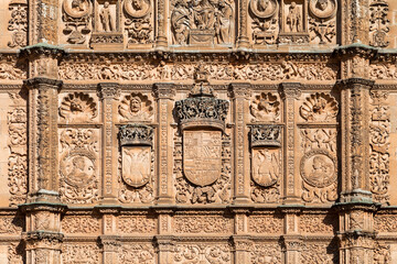 Detailed carvings and royal coats of arms on the facade of the Universidad de Salamanca in Spain